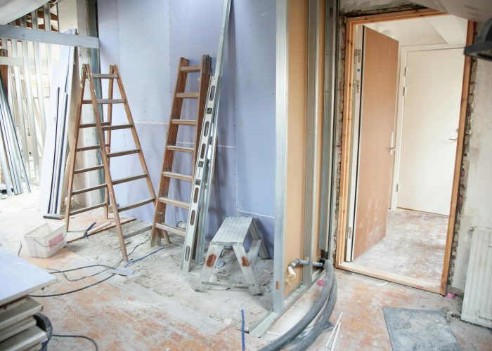 Construction site featuring ladders and tools in a home renovation setting.